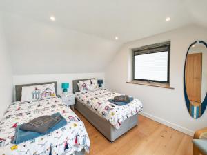 Saint Gennys2 Bed in Crackington Haven oc-h33817的有两张床和一面镜子的卧室