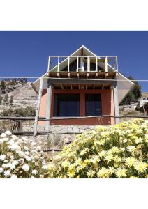 a house with a balcony on top of it at Ecolodge Aymara in Comunidad Challapampa