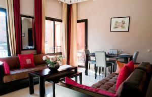 a living room with a couch and a dining room at Palacio Hôtel Condominium Marrakech in Marrakech
