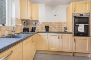 a kitchen with wooden cabinets and a sink at 2 Bed in Pooley Bridge oc-r33740 in Pooley Bridge +11 photos