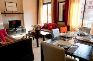 a living room with a table and a couch at Palacio Hôtel Condominium Marrakech in Marrakech
