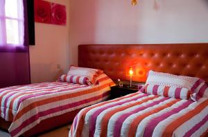 a bedroom with two beds with striped sheets at Palacio Hôtel Condominium Marrakech in Marrakech +61 photos