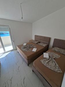 a room with three beds and a window at Apartmani Kula in Pečurice +17 photos