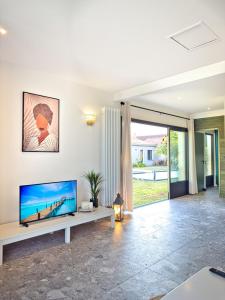 a living room with a flat screen tv on a white wall at Petit Albert in Aytré