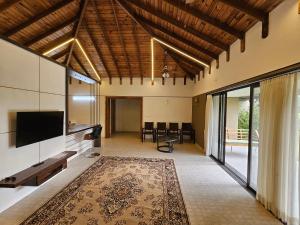 an open living room with a television and a large rug at StayGuru Luxury Villa in Bhuj