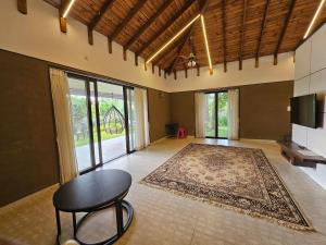a living room with a table and a rug at StayGuru Luxury Villa in Bhuj +17 photos