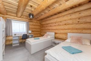 a bedroom with two beds in a wooden room at Wellness Zrub Valča in Valča