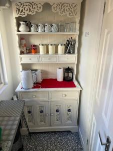 een keuken met een witte kast met een blender bij Urban Log Cabin near zone 2 tube in Londen