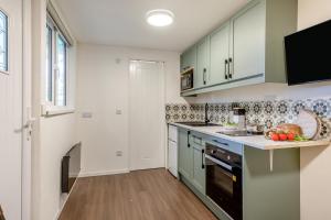 een keuken met groene kasten en een aanrecht bij 1 Bed in Wellesbourne oc-c33030 in Hampton Lucy