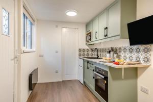 een keuken met groene kasten en een aanrecht bij 1 Bed in Wellesbourne oc-c33030 in Hampton Lucy +14 foto's