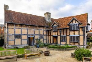 ein altes Gebäude mit zwei Bänken davor in der Unterkunft 1 Bed in Wellesbourne oc-c33029 in Hampton Lucy