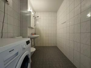 een wasmachine in een badkamer met toilet bij Kotimaailma - A cozy apartment for business guests in Seinäjoki +2 foto's