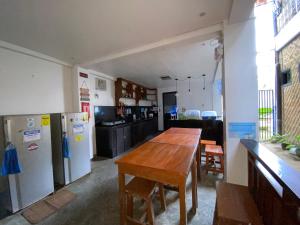 a kitchen with a wooden table and a refrigerator at Tres Islas Hostel in General Luna +4 photos