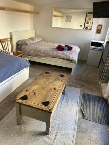 een kamer met 2 bedden en een houten tafel bij Urban Log Cabin near zone 2 tube in Londen
