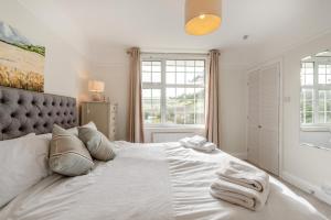 a bedroom with a large white bed with towels on it at 4 Bed in Woolacombe oc-h33441 in Mortehoe
