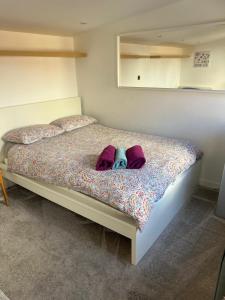 een slaapkamer met een bed met twee kussens bij Urban Log Cabin near zone 2 tube in Londen