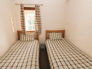 two twin beds in a room with a window at Knap Cottage in Walton East +25 photos