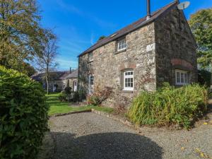 an old stone house with white windows and a yard at Carthouse Cottage in Walton East