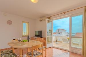 een eetkamer met een tafel en uitzicht op de oceaan bij Miljenko in Novalja