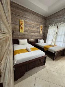 una camera da letto con due letti in una stanza di Tiki bar and more a Nusa Lembongan Altre 75 foto
