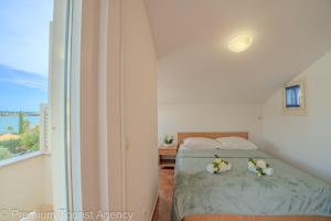 een slaapkamer met een bed met bloemen erop bij Miljenko in Novalja