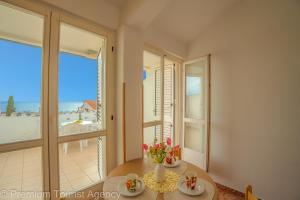 een eetkamer met een tafel en uitzicht op de oceaan bij Miljenko in Novalja