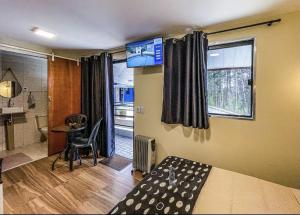 a bedroom with a bed and a table and a window at Villa de Recriary in Campos do Jordão