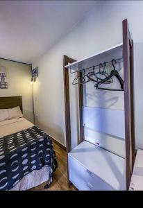 a bedroom with a bed and a dresser with a shelf at Villa de Recriary in Campos do Jordão