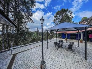 a patio with a light pole and a table and chairs at Villa de Recriary in Campos do Jordão
