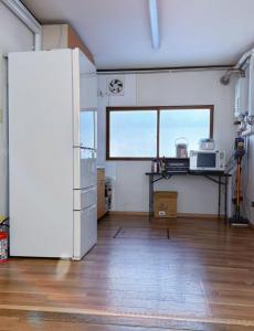 a large room with a kitchen with a table and a microwave at NisekoSnowHouse in Abuta