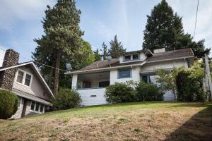 a white house on a hill with trees at Daisy's Place 30 day minimum in Hood River