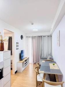 a living room with a table and chairs in a room at Davao 1BR Condo for 4 with Pool Near SM Lanang and Airport in Davao City