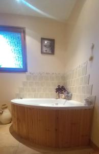 une baignoire dans une salle de bain avec une fenêtre dans l'établissement Au gîte de Saint Peyre, à Ribeyret