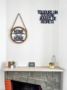 a fireplace with a sign on a white wall at Le Grand Horizon Rochelais, plage à 5min, parking in La Rochelle +19 photos