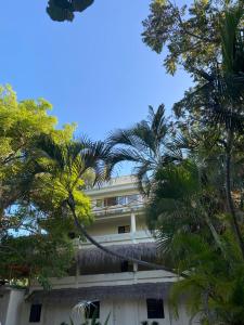 a building with palm trees in front of it at MK BEACH Playa Del Carmen in Playa del Carmen