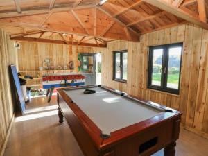 a pool table in a room with wooden walls at Swallows Cottage in Walton East