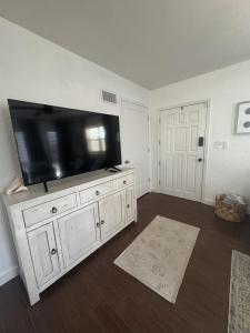 una sala de estar con una gran TV de pantalla plana en una cómoda en Cozy Jax Beach Pool Home!, en Jacksonville Beach