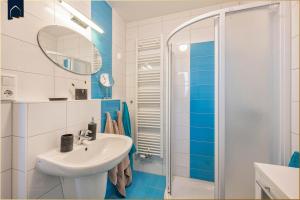 ein blau-weißes Bad mit einem Waschbecken und einer Dusche in der Unterkunft Paul-Kühne-Str 4 Tintenfisch in Ostseebad Koserow + 29 Fotos
