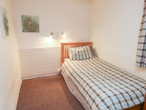 - une petite chambre avec un lit et une couverture tressée dans l'établissement Stable Cottage, à Walton East 26 autres photos