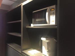 a microwave sitting on top of a shelf in a kitchen at Gran Custama Ueno in Tokyo