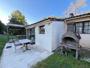 d'une terrasse avec une cheminée et une table. dans l'établissement Maison à la campagne 4 à 6 personnes proche JONZAC, à Boisredon