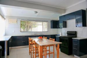 a kitchen with blue cabinets and a table with chairs at 326onMackenzieSt in Pretoria