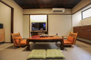 - un salon avec une table en bois et 2 chaises dans l'établissement 東京下町生活, à Tokyo