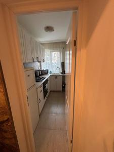 a kitchen with white cabinets and a white appliances at Elena Apartament in Suceava