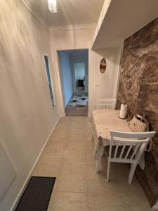 a dining room with a table and a stone wall at Elena Apartament in Suceava