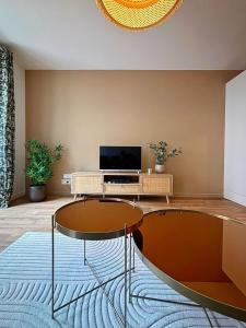 a living room with a table and a tv at Joli Perot, Confortable, centre, 5 min du port in La Rochelle +13 photos