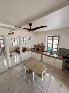 a kitchen with a table and a ceiling fan at Creole Kaz in Le François