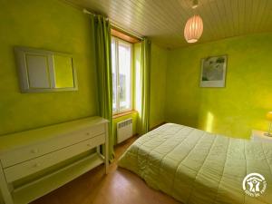 ein grünes Schlafzimmer mit einem Bett und einem Fenster in der Unterkunft Bel Air in Peyrusse-le-Roc