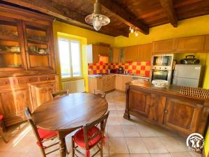 eine Küche mit Holztisch und ein Esszimmer in der Unterkunft Bel Air in Peyrusse-le-Roc + 19 Fotos
