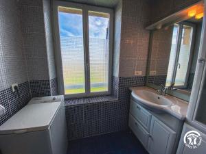 ein Badezimmer mit Waschbecken, Badewanne und Fenster in der Unterkunft Bel Air in Peyrusse-le-Roc